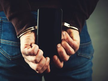 Arrested person holding a phone