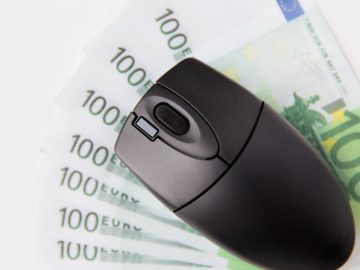 business, finance, internet earning and technology concept - close up of computer mouse and euro cash money on table