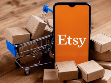Fake Etsy invoice scam tricks sellers into sharing credit card information Image of a phone with an Etsy logo on it in front of boxes and a shopping trolley